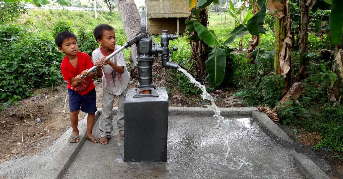 Children using a hand pump in south philippines